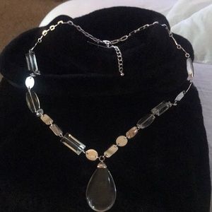 Clear lucite and silver long costume necklace.  Length from clasp to charm 16 “.